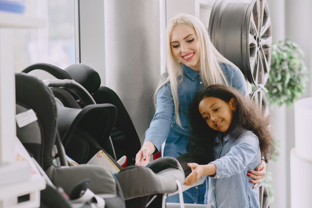 femme dans un magasin de siege auto pour bébé avec un enfant